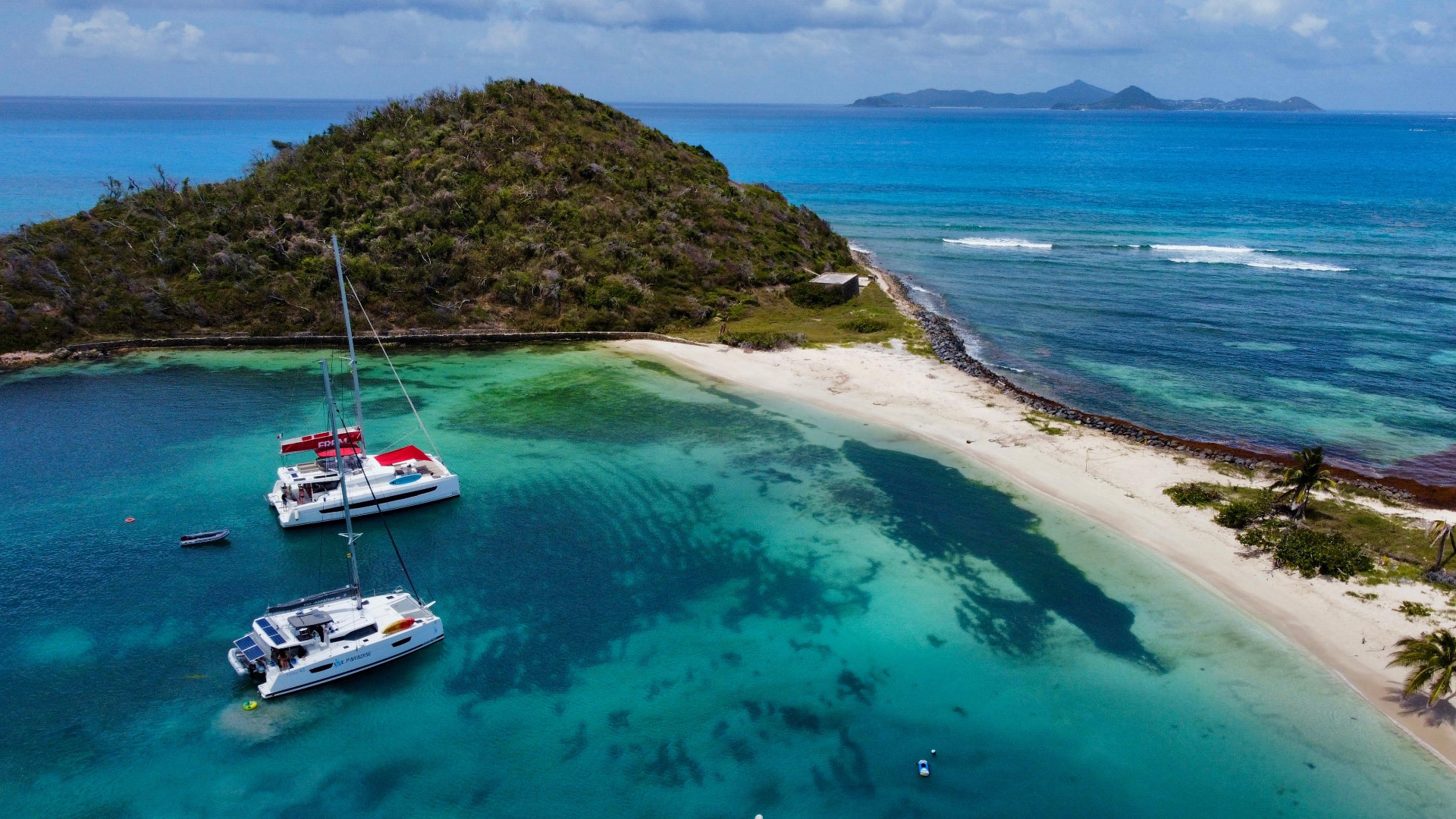Deux catamarans dans une baie turquoise aux eaux cristallines
